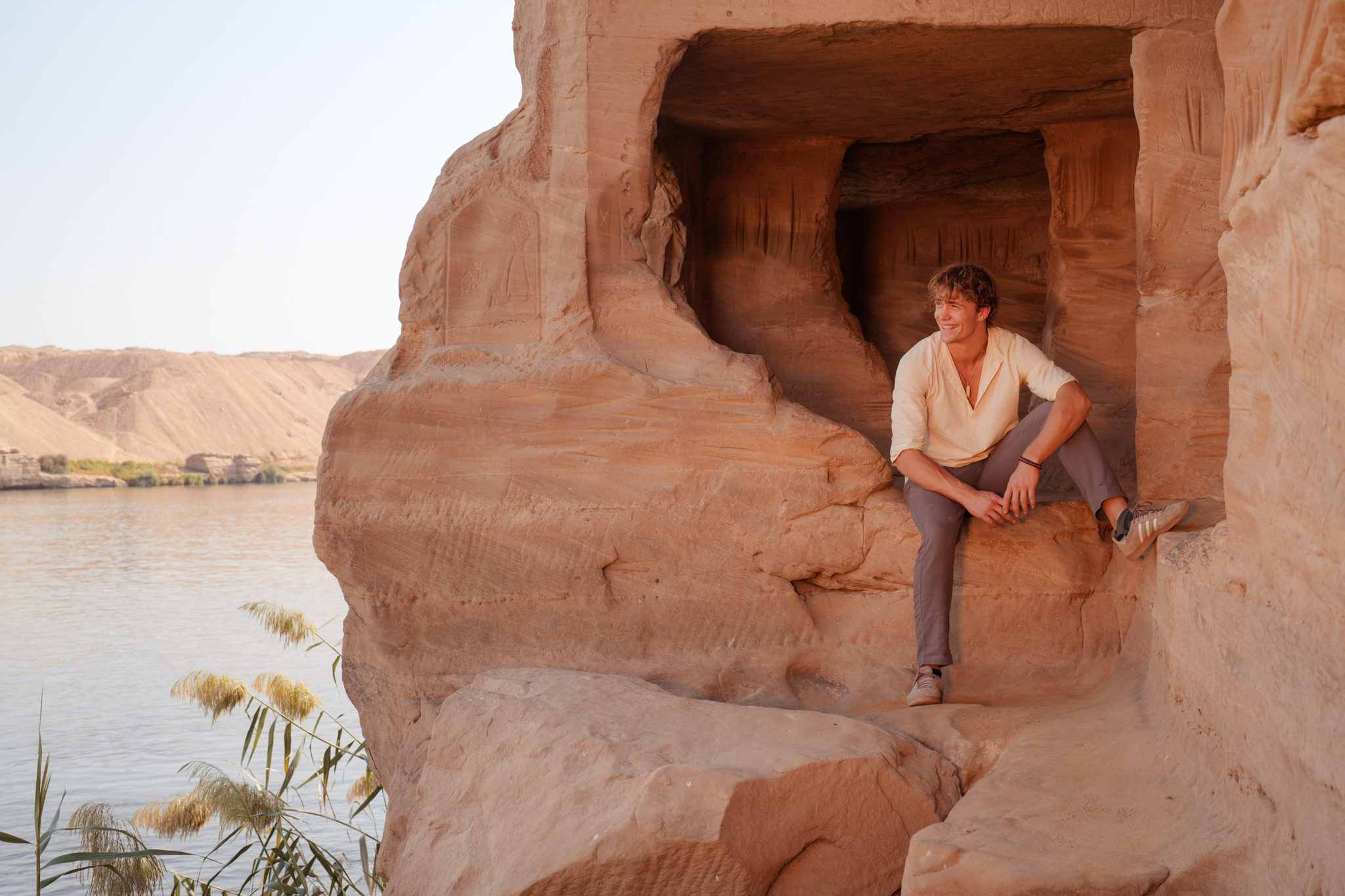 Kai Brown sitting on ancient sandstone cliffs by the Nile